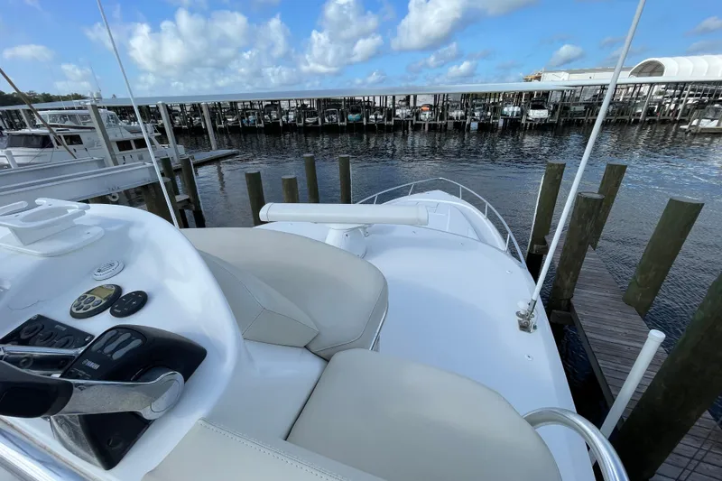 Slide: The Image of 2009 Intrepid 430 Sport Yacht docked at marina, featuring helm controls and seating. - 17