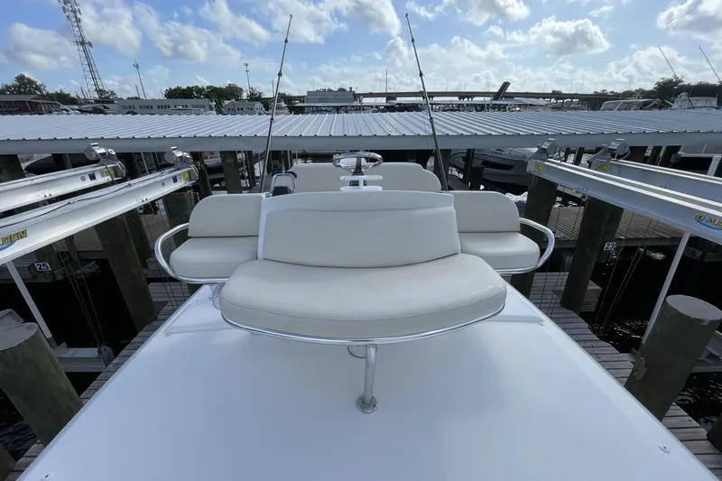Slide: The Image of 2009 Intrepid 430 Sport Yacht with white seating, docked under a cloudy sky. - 19
