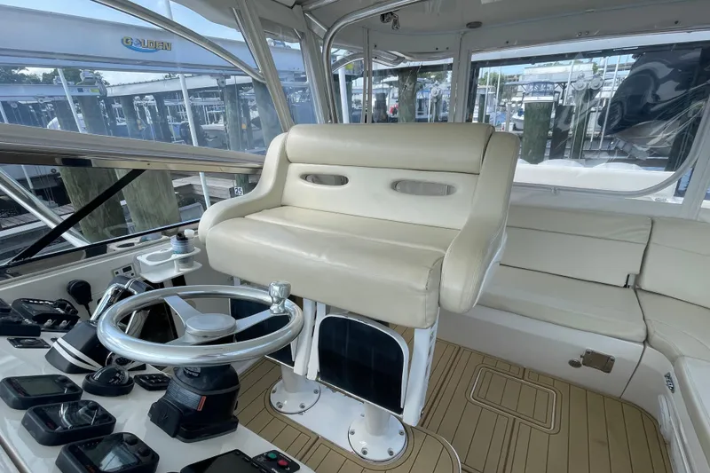 Slide: The Image of 2009 Intrepid 430 Sport Yacht helm with beige seating and modern controls. - 33