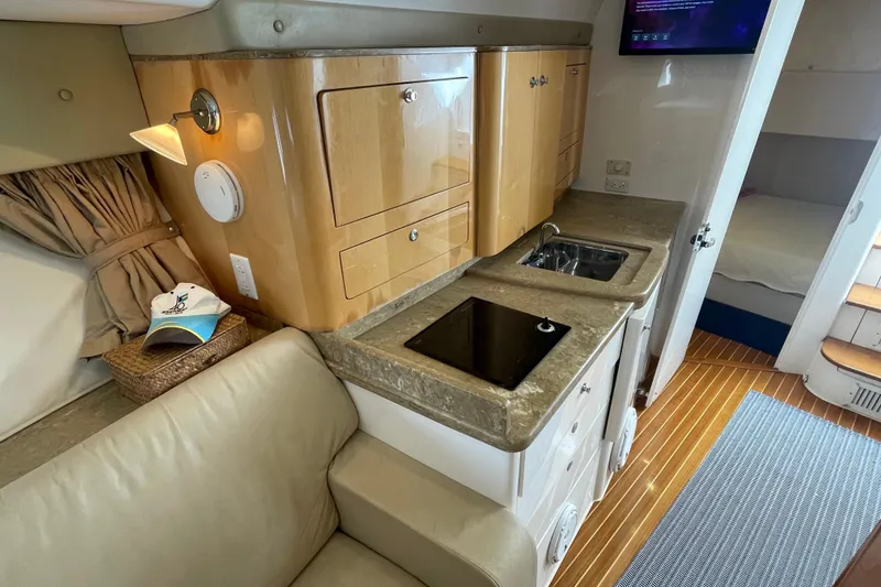 Slide: The Image of Luxurious 2009 Intrepid 430 Sport Yacht interior with kitchenette, sink, and cozy seating area. - 49