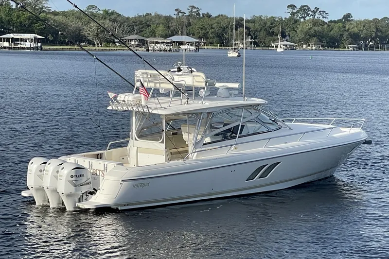 Slide: The Image of 2009 Intrepid 430 Sport Yacht on calm water, featuring triple Yamaha outboard engines. - 7