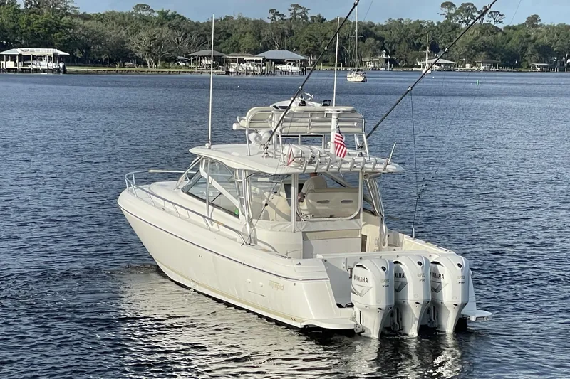 Slide: The Image of 2009 Intrepid 430 Sport Yacht on calm water with triple Yamaha engines. - 8