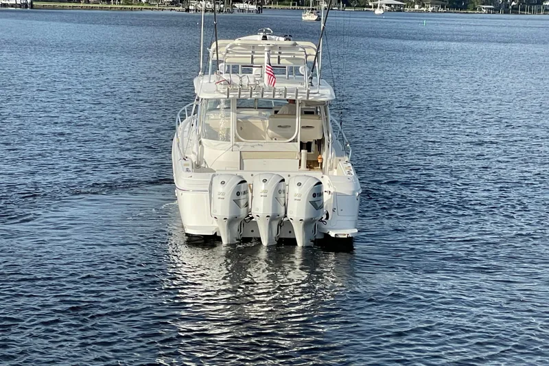 Slide: The Image of 2009 Intrepid 430 Sport Yacht on calm water, rear view with triple engines. - 9