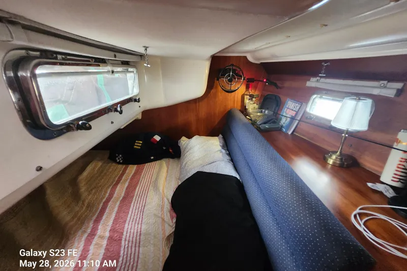 Slide: The Image of Cozy cabin interior of a 1995 Freedom 35 sailboat with bedding and nautical decor. - 13