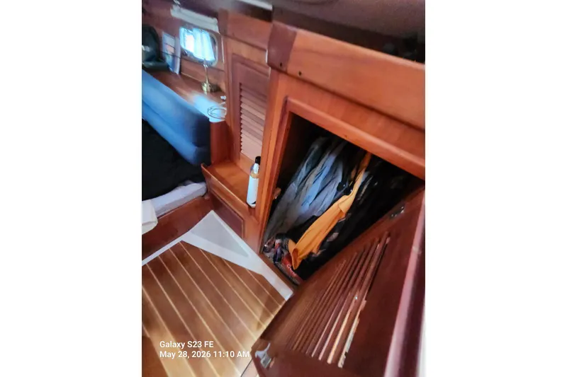 Slide: The Image of Interior of a 1995 Freedom 35 sailboat with wooden cabinetry and cozy furnishings. - 14