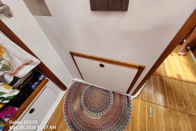 Slide: The Image of Interior of a 1995 Freedom 35 boat with colorful circular rug and wooden flooring. - 15