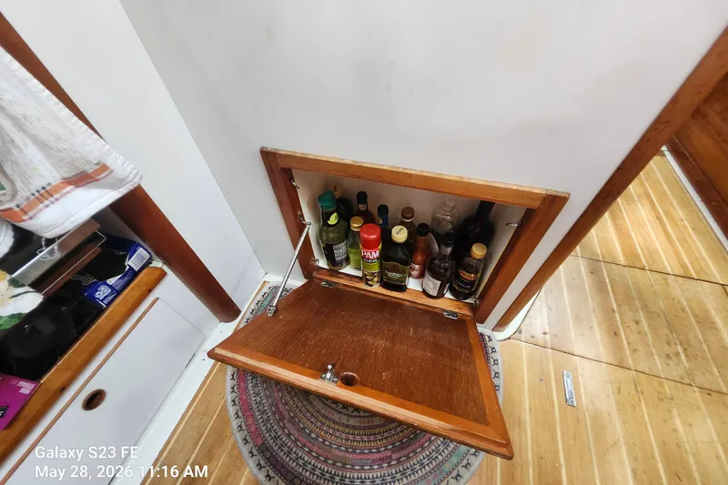 Slide: The Image of Hidden cabinet with assorted bottles on a 1995 Freedom 35 boat. - 16