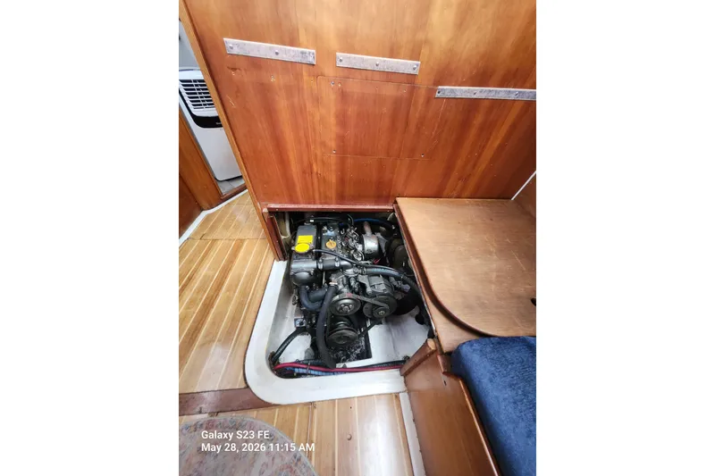 Slide: The Image of Engine compartment of a 1995 Freedom 35 sailboat, showcasing wooden interior and mechanical components. - 18
