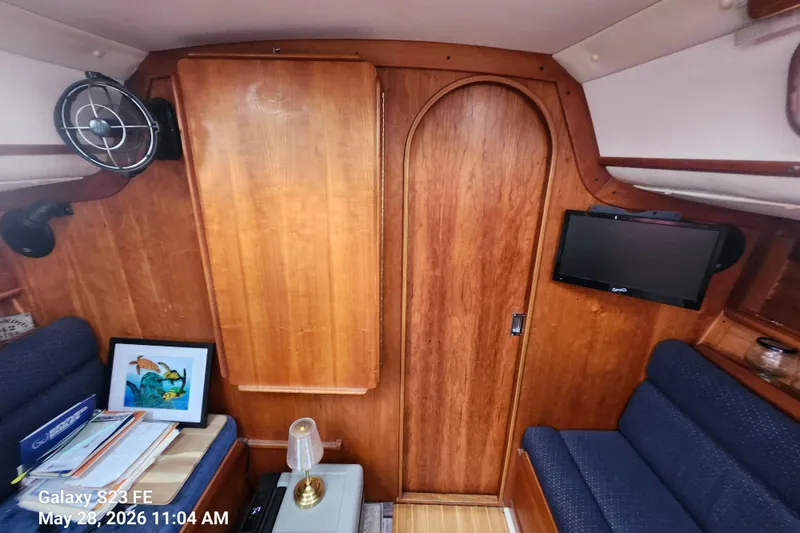 Slide: The Image of Interior of a 1995 Freedom 35 sailboat with wood paneling and cozy seating. - 23