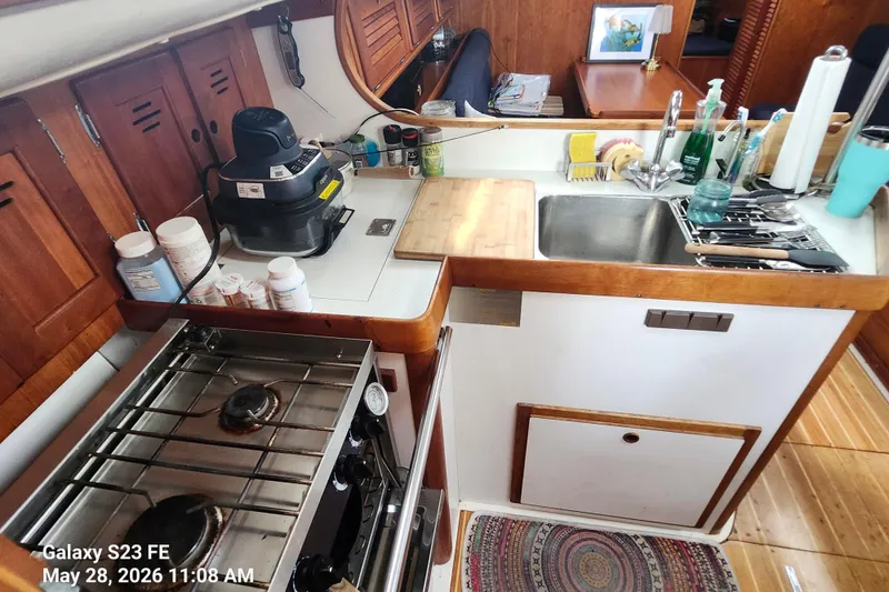 Slide: The Image of Compact kitchen in a 1995 Freedom 35 sailboat with stove, sink, and appliances. - 24