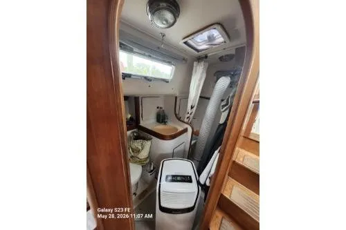 Slide: The Image of Interior of a 1995 Freedom 35 sailboat, featuring a compact bathroom with wooden accents. - 25
