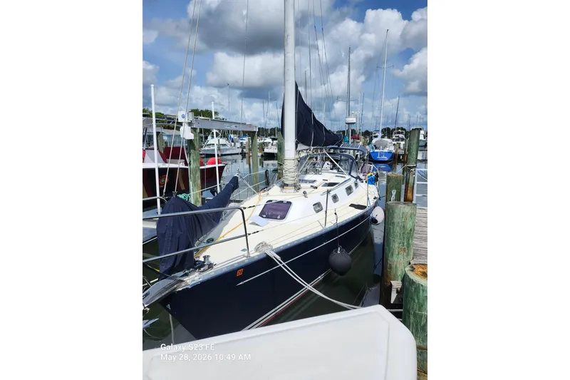 Slide: The Image of Sailboat Freedom 35, 1995 model, docked at marina under cloudy sky. - 26
