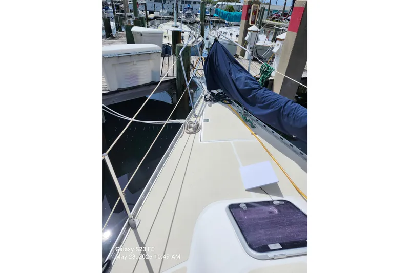 Slide: The Image of Sailboat deck view of 1995 Freedom 35 at marina, featuring rigging and covered sail. - 28