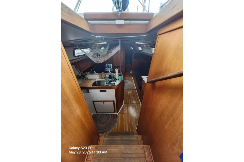 Slide: The Image of Interior of a 1995 Freedom 35 sailboat with wooden finishes and compact kitchen area. - 3
