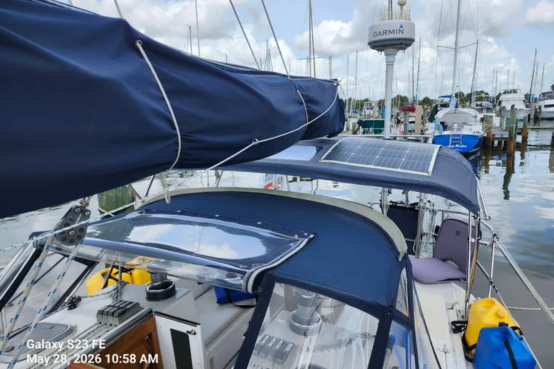 Slide: The Image of Sailboat Freedom 35 (1995) with solar panels docked at a marina, featuring Garmin equipment. - 30