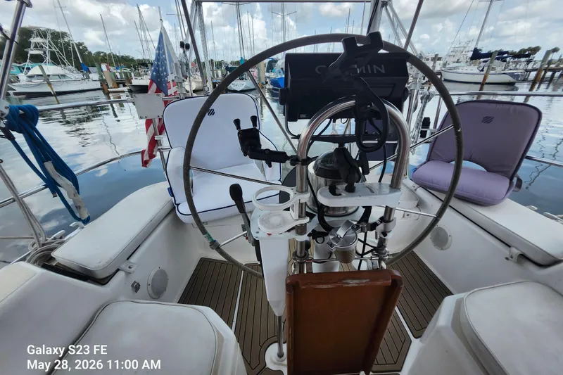 Slide: The Image of Cockpit of 1995 Freedom 35 sailboat with steering wheel and marina view. - 35