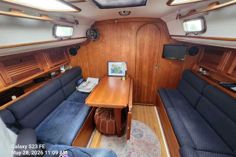 Slide: The Image of Cozy interior of a 1995 Freedom 35 sailboat with wooden furnishings and blue seating. - 4