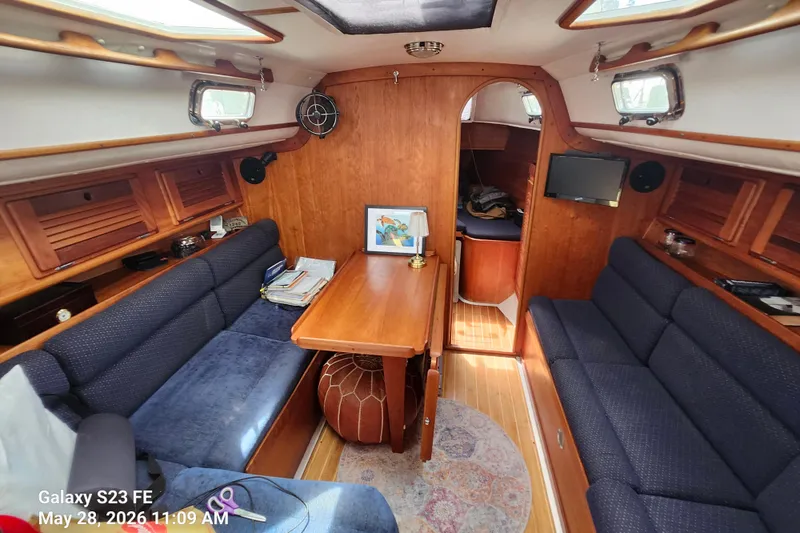 Slide: The Image of Interior of a 1995 Freedom 35 sailboat with cozy seating and wooden finishes. - 5