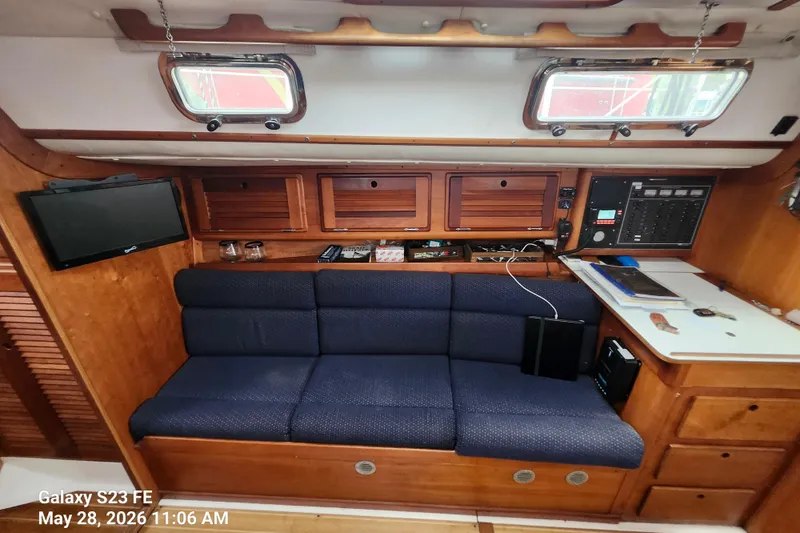 Slide: The Image of Interior of a 1995 Freedom 35 sailboat with blue seating and wooden cabinetry. - 6