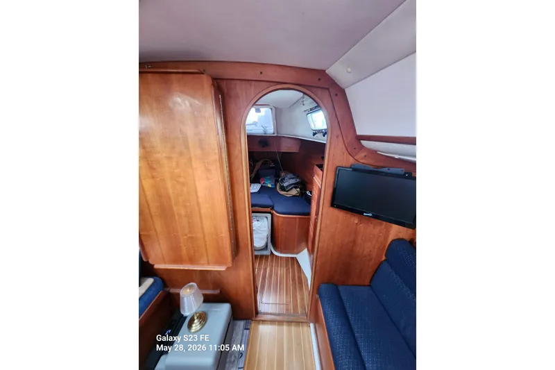 Slide: The Image of Interior of a 1995 Freedom 35 sailboat, featuring wood paneling and a cozy cabin layout. - 9