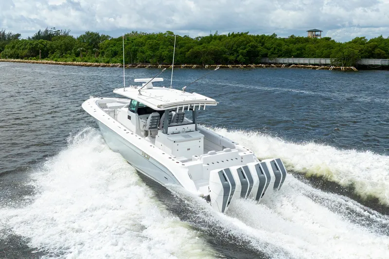 Slide: The Image of 2026 HCB 42 Lujo boat cruising on a scenic waterway with lush greenery. - 10