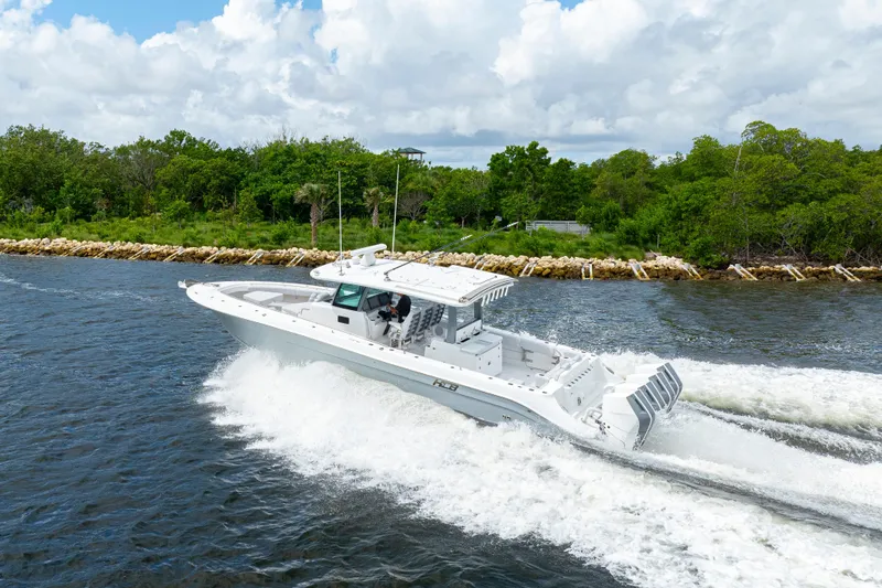 Slide: The Image of 2026 HCB 42 Lujo boat cruising on a scenic waterway with lush greenery. - 11