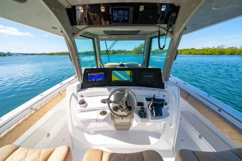 Slide: The Image of Helm of 2027 HCB 42 Lujo boat with advanced navigation systems on a serene waterway. - 20