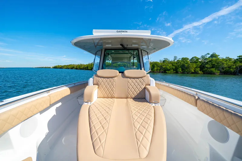 Slide: The Image of Luxurious 2027 HCB 42 Lujo boat interior with tan seating, cruising on a serene blue lake. - 36