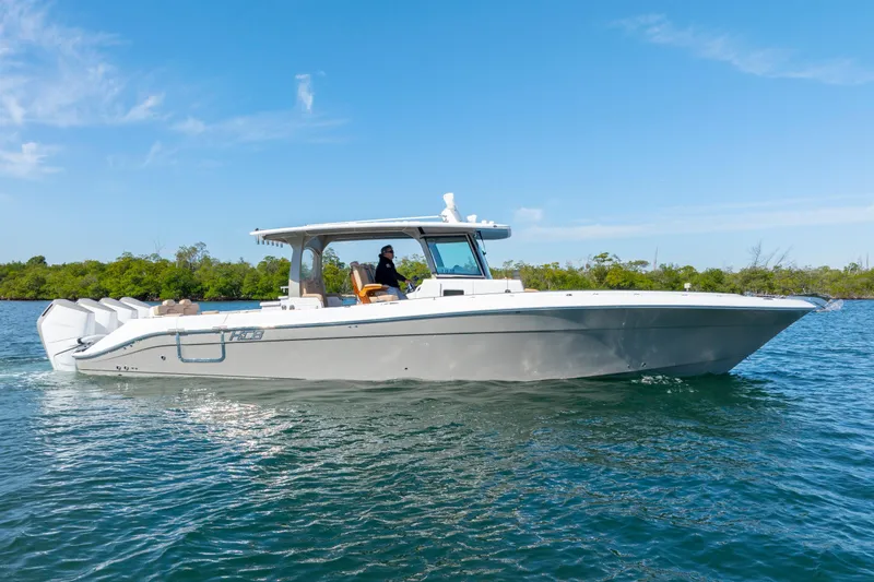 Slide: The Image of 2027 HCB 42 Lujo boat cruising on clear blue water under a sunny sky. - 4