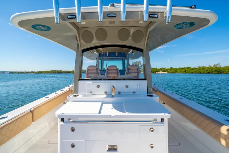 Slide: The Image of 2027 HCB 42 Lujo boat interior with seating and storage on calm water. - 46