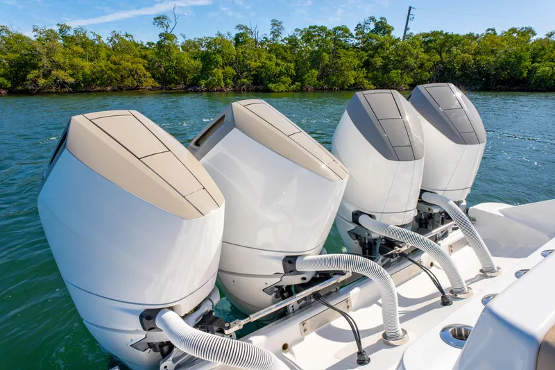 Slide: The Image of Four powerful outboard engines on a 2027 HCB 42 Lujo boat, cruising in clear waters. - 48