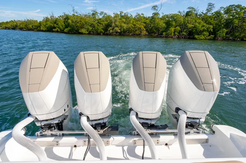Slide: The Image of Four powerful outboard motors on a 2027 HCB 42 Lujo boat cruising through water. - 49