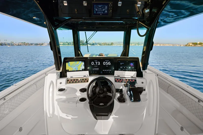 Slide: The Image of Helm of 2026 HCB 42 Lujo boat with advanced navigation displays on open water. - 43