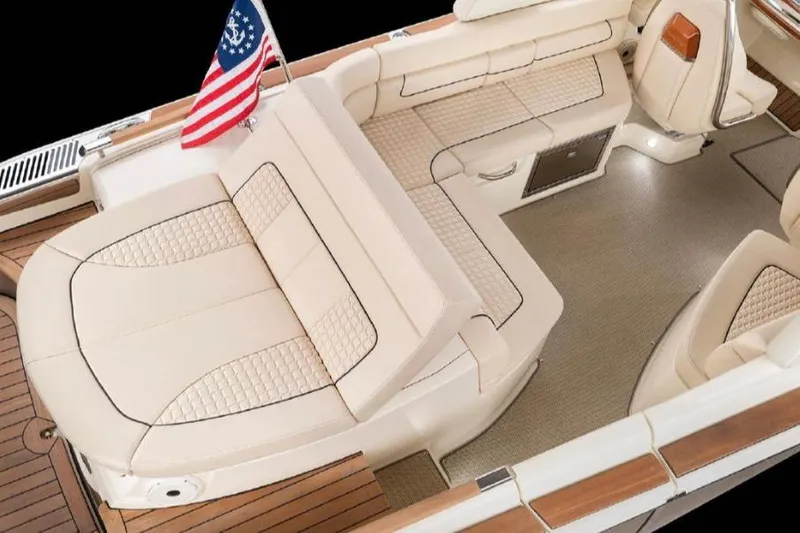 Slide: The Image of 2022 Chris-Craft Launch 25 GT boat interior with beige seating and American flag. - 5