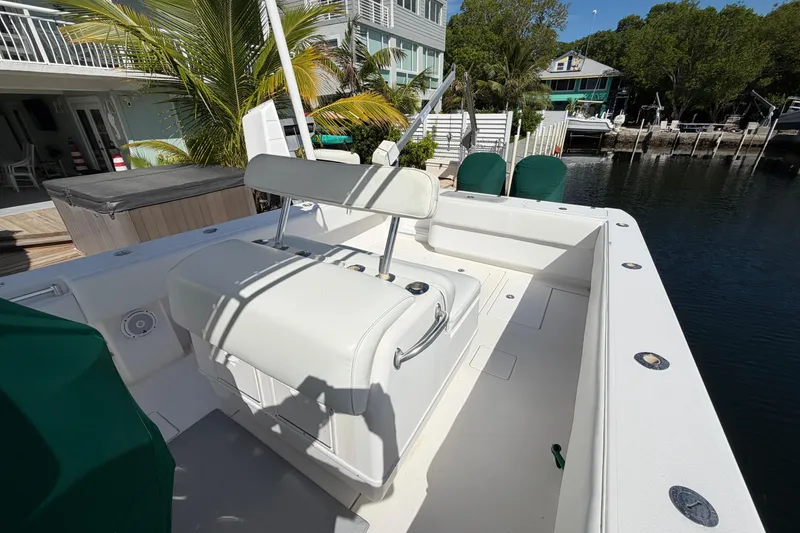 Slide: The Image of 2007 Contender 33 Tournament boat docked near waterfront homes, featuring spacious deck and seating. - 18