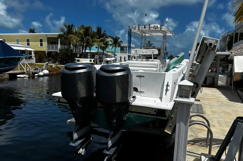 Slide: The Image of 2007 Contender 33 Tournament boat docked with dual outboard motors, tropical setting. - 6
