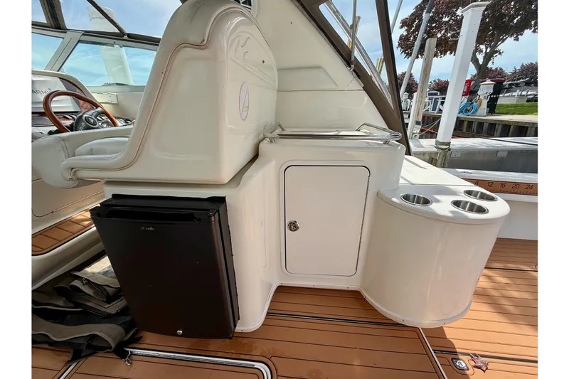 Slide: The Image of 1997 Sea Ray 330 Express Cruiser interior with fridge, storage, and cup holders. - 10