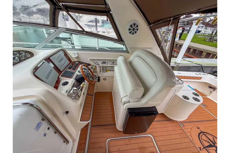 Slide: The Image of 1997 Sea Ray 330 Express Cruiser helm with Garmin navigation, leather seating, and wood flooring. - 11