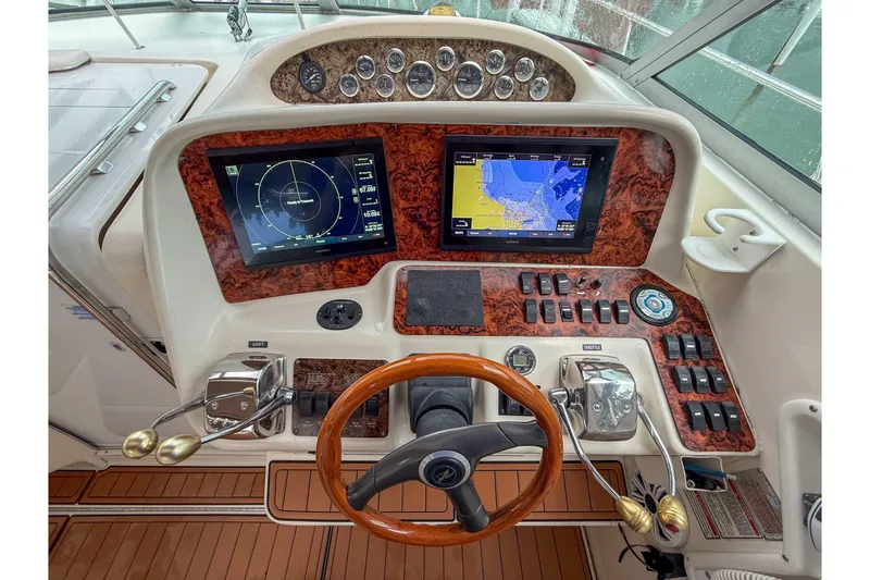 Slide: The Image of 1997 Sea Ray 330 Express Cruiser dashboard with navigation screens and wooden steering wheel. - 13