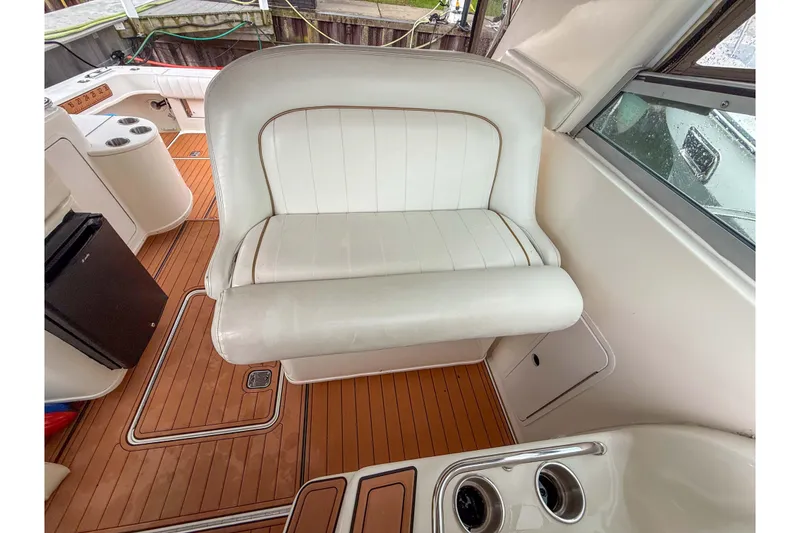 Slide: The Image of 1997 Sea Ray 330 Express Cruiser interior with white seating and wood flooring. - 16