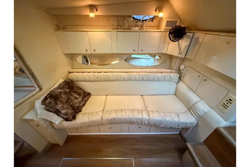Slide: The Image of Interior of 1997 Sea Ray 330 Express Cruiser with white leather seating and cozy lighting. - 18