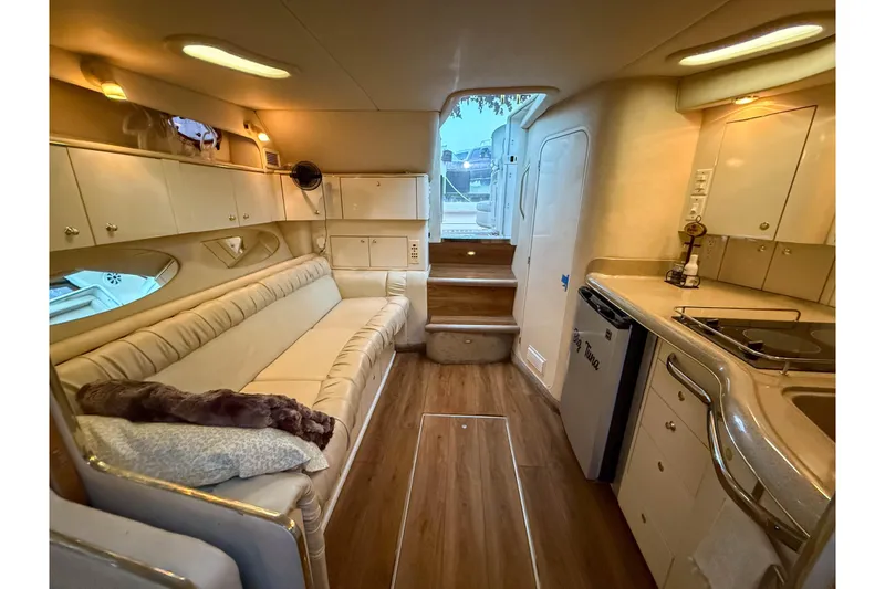 Slide: The Image of Interior of 1997 Sea Ray 330 Express Cruiser with cozy seating and compact kitchen. - 21