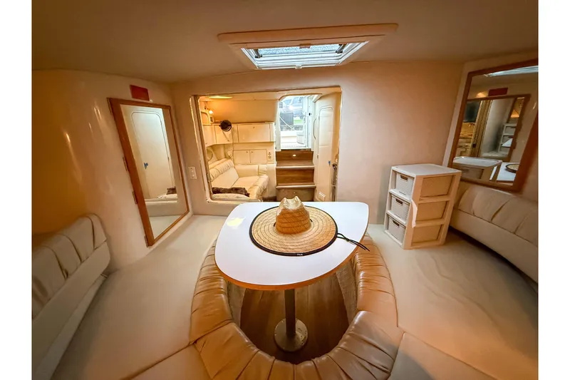 Slide: The Image of Interior of 1997 Sea Ray 330 Express Cruiser with cozy seating and table. - 23