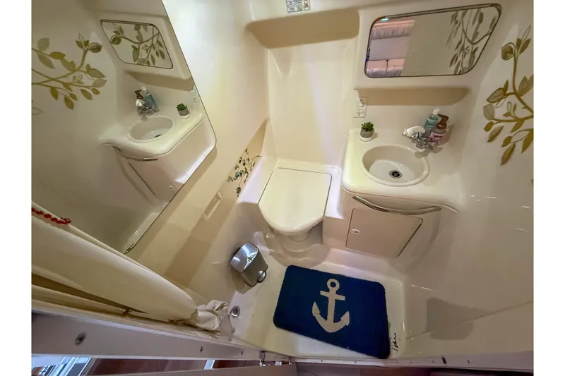 Slide: The Image of Bathroom interior of 1997 Sea Ray 330 Express Cruiser with nautical decor and compact design. - 24