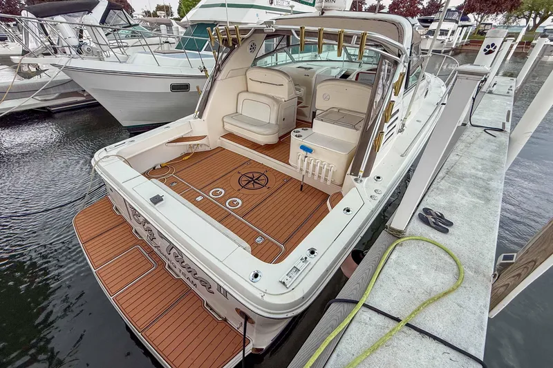 Slide: The Image of 1997 Sea Ray 330 Express Cruiser docked, featuring spacious deck and seating area. - 3