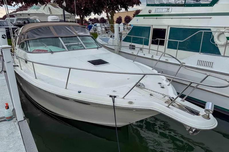 Slide: The Image of 1997 Sea Ray 330 Express Cruiser docked at marina, showcasing sleek design and spacious deck. - 6