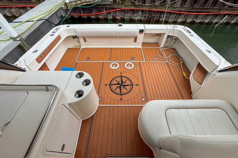 Slide: The Image of 1997 Sea Ray 330 Express Cruiser deck with compass design, docked at marina. - 7