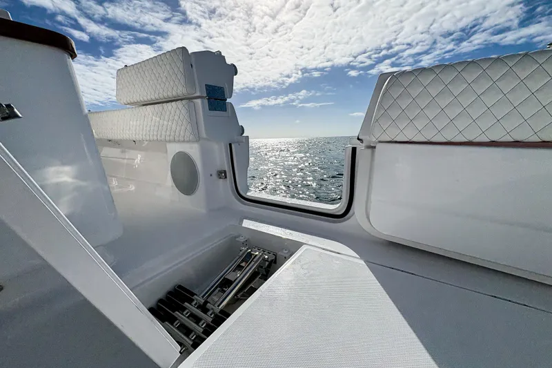 Slide: The Image of 2027 HCB 48 Campeon boat interior with ocean view, featuring white quilted seating. - 23