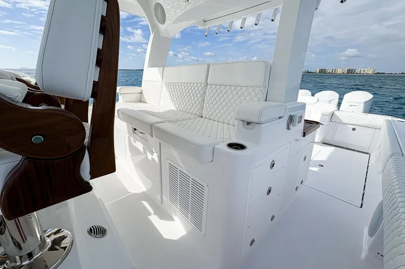 Slide: The Image of 2027 HCB 48 Campeon luxury boat interior with white seating and ocean view. - 27