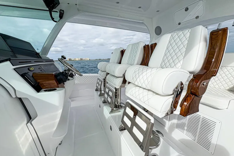 Slide: The Image of Luxurious interior of 2027 HCB 48 Campeon boat with plush white seating and modern controls. - 36